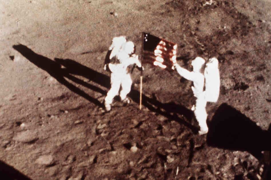 On July 20, 1969, Apollo 11 astronauts Armstrong and Aldrin, the first men to land on the moon, plant the U.S. flag on the lunar surface.