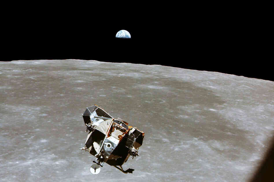 With a half-Earth in the background, the lunar module, in its ascent stage with moon-walking Armstrong and Aldrin, approaches for a rendezvous with the Apollo command module, manned by Collins.