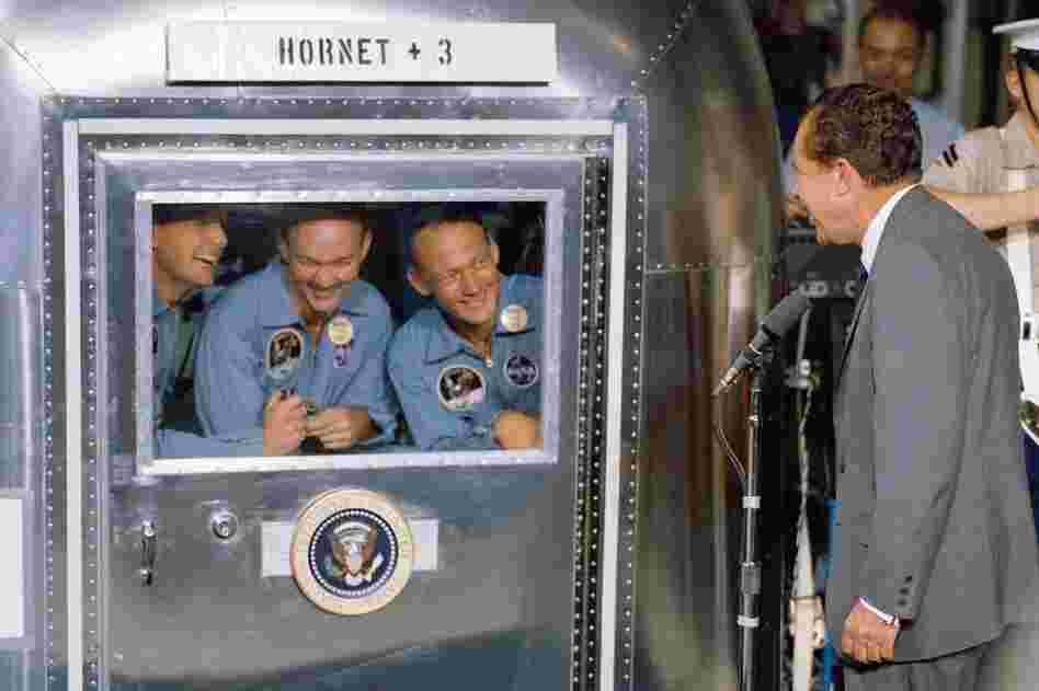 President Richard Nixon welcomes the Apollo 11 astronauts aboard the USS Hornet, prime recovery ship for the lunar landing mission. Armstrong (left) and his fellow colleagues are in the mobile quarantine facility.