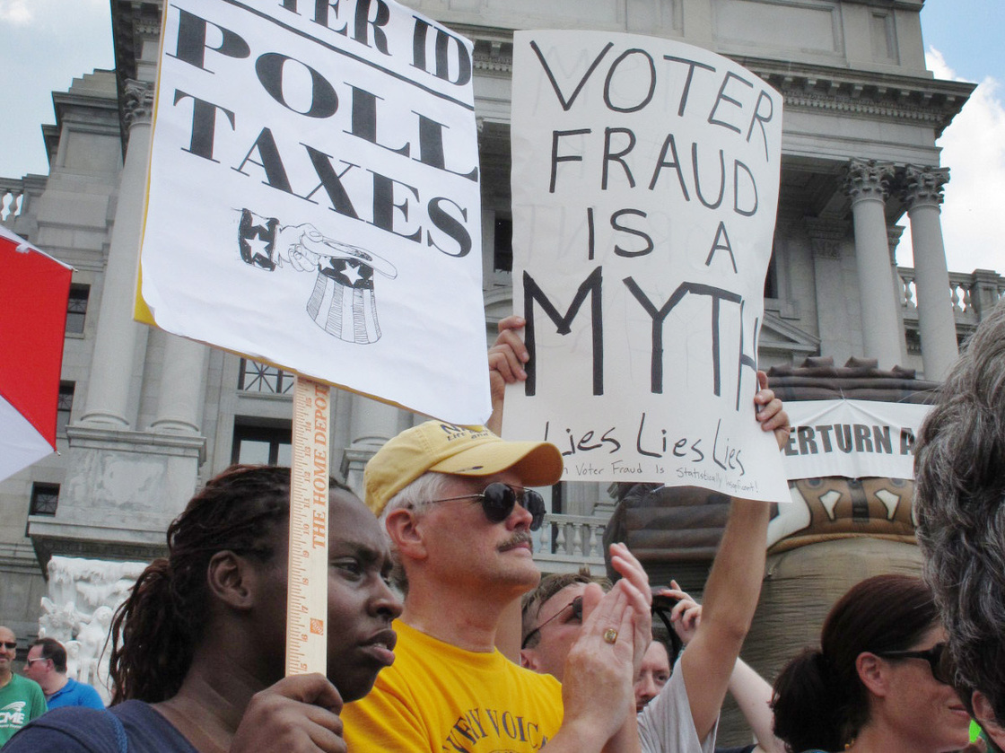 Demonstrators hold signs at an NAACP-organized rally on the steps of the Pennsylvania Capitol to protest the state's new voter identification law on July 24 in Harrisburg, Pa.