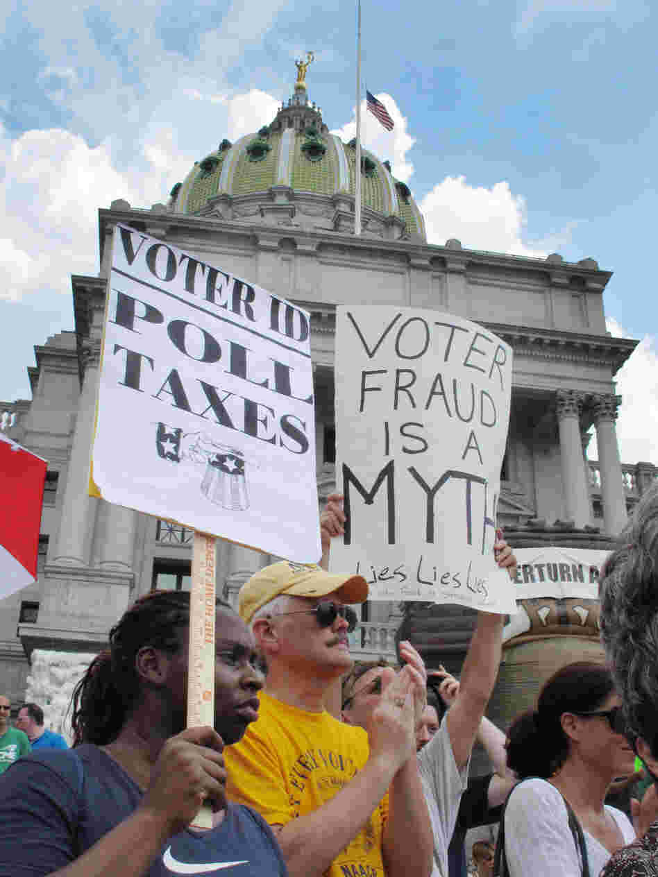 Demonstrators hold signs at an NAACP-organized rally on the steps of the Pennsylvania Capitol to protest the state's new voter identification law on July 24 in Harrisburg, Pa.