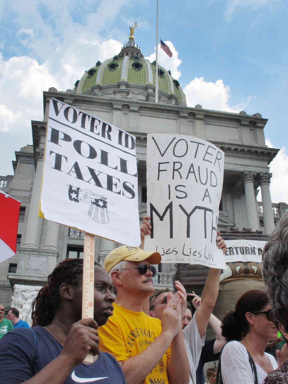 Demonstrators hold signs at an NAACP-organized rally on the steps of the Pennsylvania Capitol to protest the state's new voter identification law on July 24 in Harrisburg, Pa.
