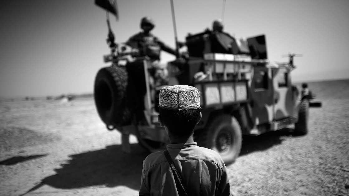 A boy watches a group of Afghan and U.S. commandos in their up armored Humvee in Shindand Afghanistan. The special forces have become more prominent in the U.S. war effort.