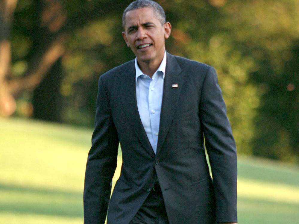 President Barack Obama walks across the South Lawn to the White House after returning from campaigning August 18, 2012 in Washington D.C.