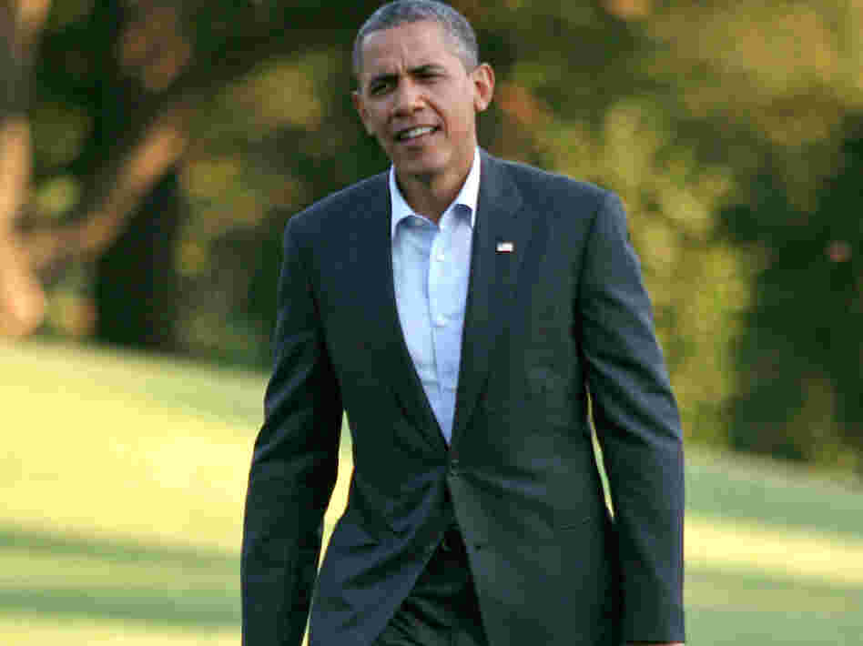 President Barack Obama walks across the South Lawn to the White House after returning from campaigning August 18, 2012 in Washington D.C.