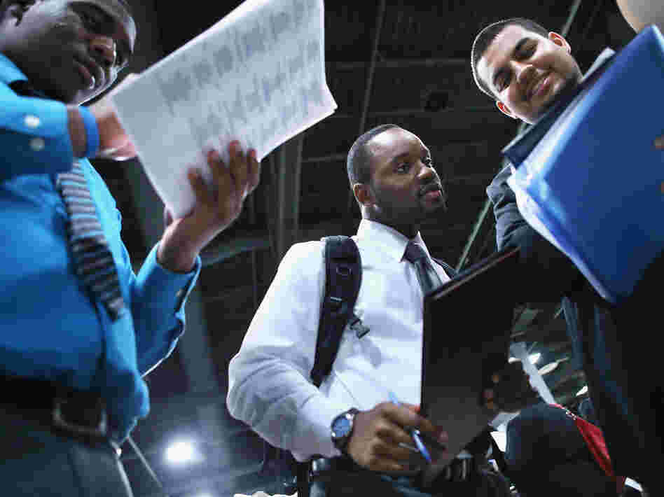 Young job-seekers look over a list of 85 business participating in a job fair last week in Washington, D.C.