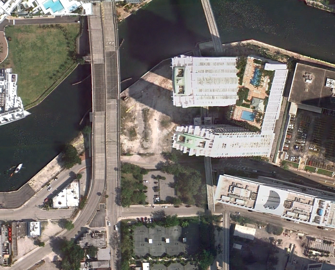A Google Earth image from March 2011 shows the area Brickell Green Space envisions as a park. The plot is directly south of the river, to the left of the high-rises.