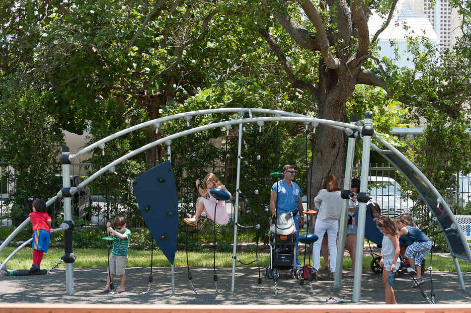 Children play at the 1814 Brickell Park, a new park that features benches, a paved path and a monument made of a girder from the World Trade Center.