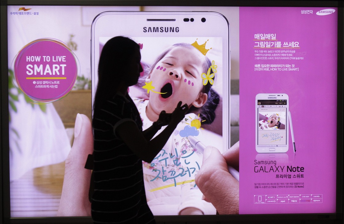 A woman walks across banner advertising for Samsung Electronics' Galaxy Note Seoul, South Korea on Monday.