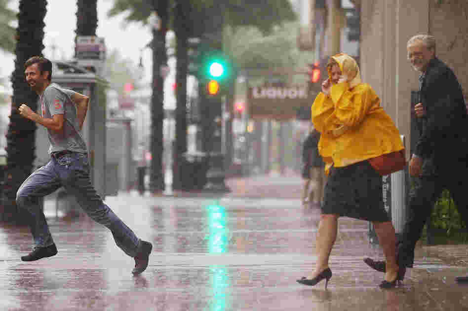 People make their way across Canal Street in New Orleans. Ed Rappaport, deputy director of the National Hurricane Center, said Isaac's core would pass west of the city and head for Baton Rouge.