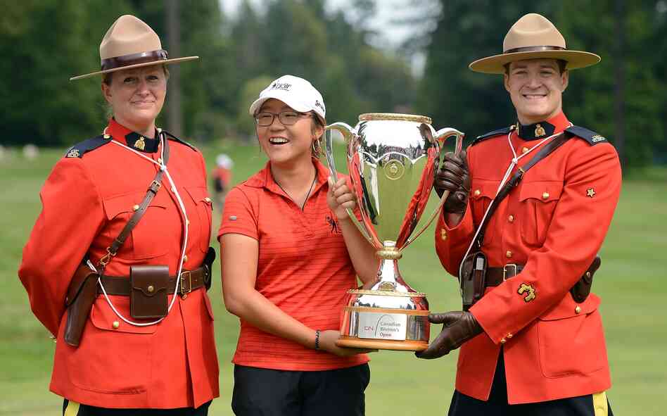 Lydia Ko accepts her winner's trophy at the CN Canadian Women's Open in Vancouver, surrounded by members of the RCMP.