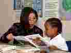 A Read Aloud Delaware volunteer reads to a student.