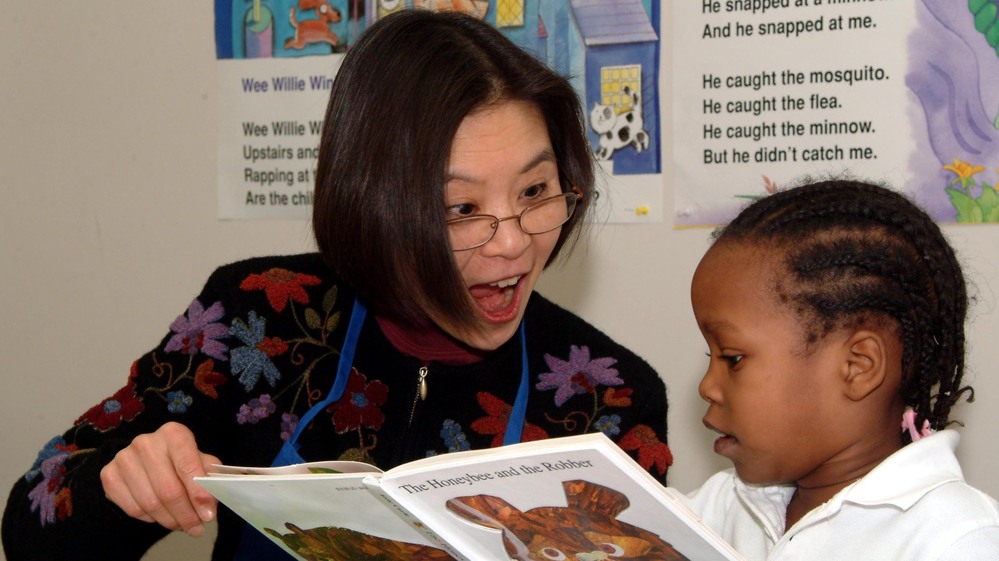 A Read Aloud Delaware volunteer reads to a student.