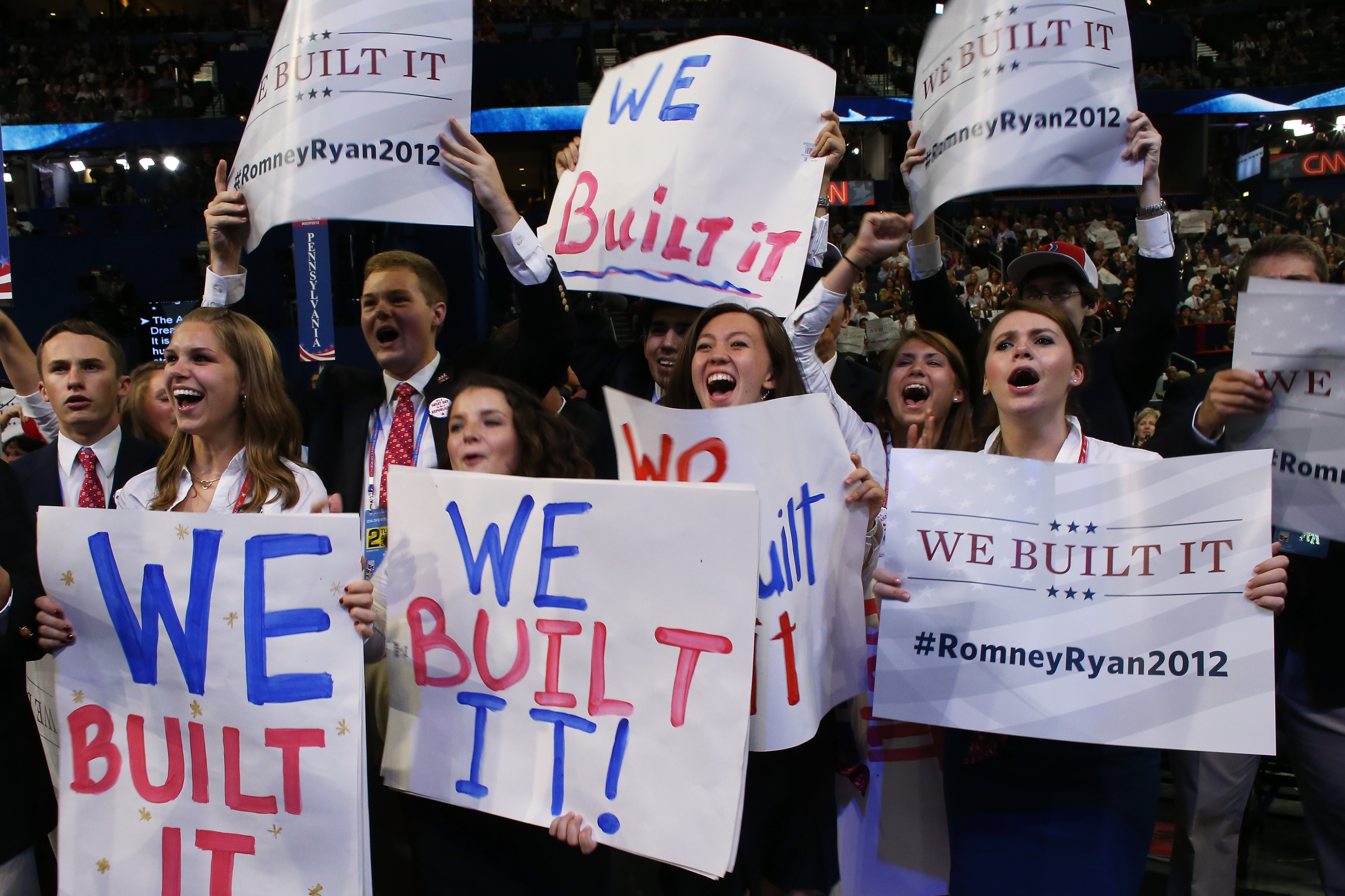 People hold signs that read "We Built It" during the convention.