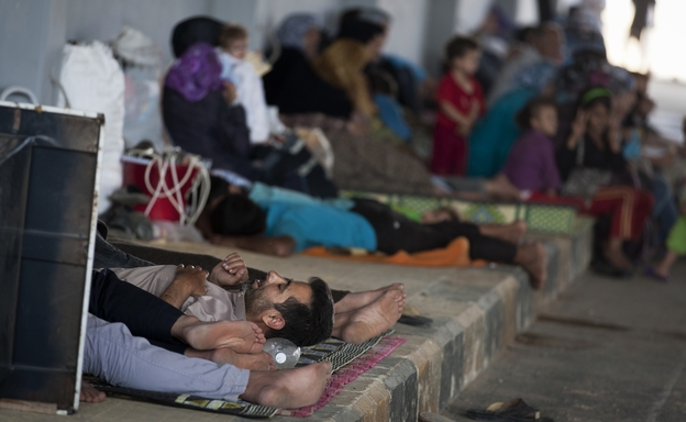 Syrians wait on the Syrian side of the border to be admitted to Turkey on Wednesday, Aug. 15.