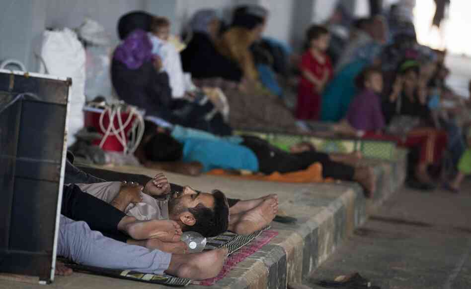 Syrians wait on the Syrian side of the border to be admitted to Turkey on Wednesday, Aug. 15.