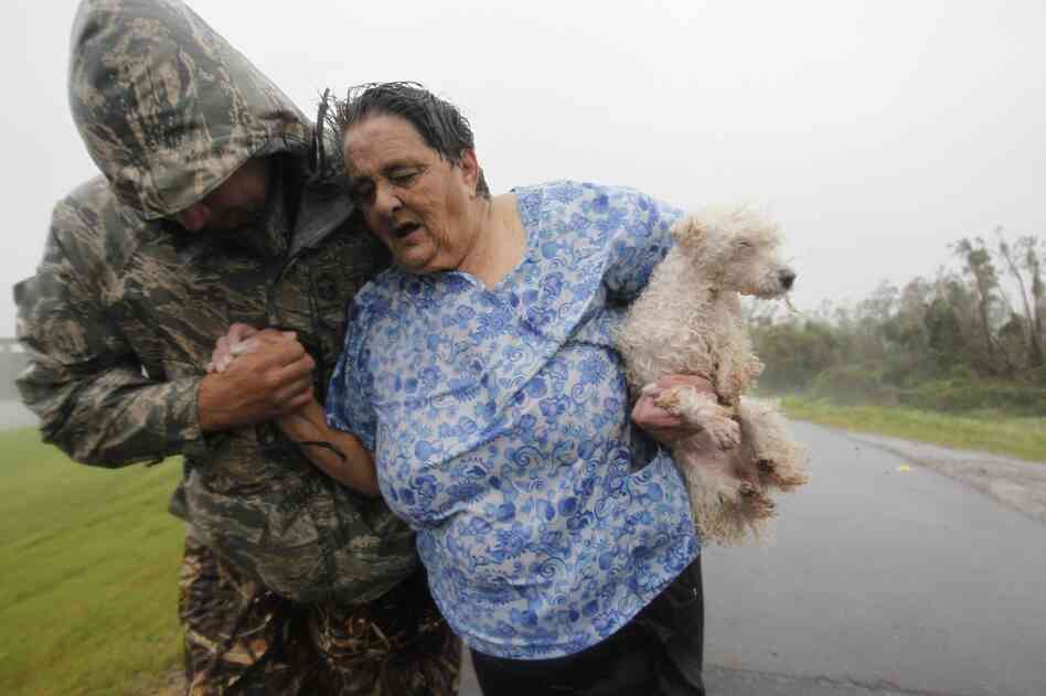 First responders carry people across the top of the levee from Plaquemines Parish to St. Bernard Parish as Hurricane Isaac sends powerful winds and rain through the area.