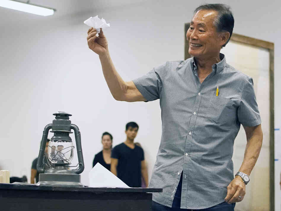 Takei rehearses a scene in which his character, Ojii-San, tries to cheer his granddaughter up by making her an origami flower out of a loyalty questionnaire.