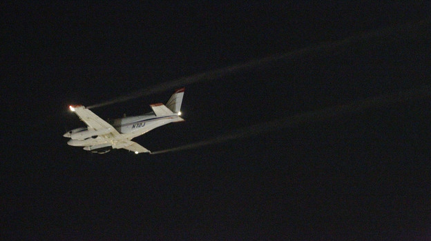 A Beechcraft airplane sprays insecticide over Dallas early Monday morning to curb the spread of West Nile virus.