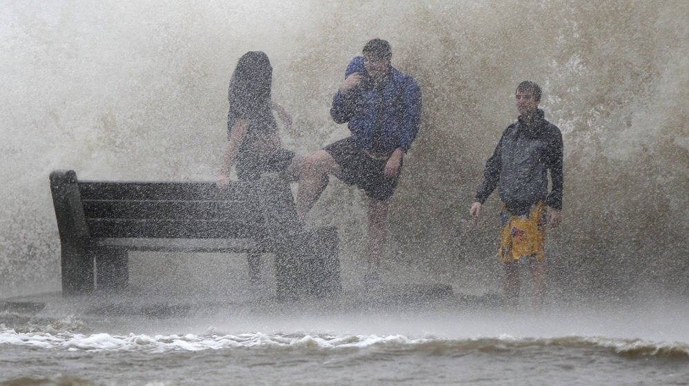 People walk in the storm surge from Hurricane Isaac along Lake Pontchartrain in New Orleans. Isaac was later downgraded to a tropical storm as it continued to grind its way through the Gulf Coast, dropping torrential rain and generating dangerous storm surges.