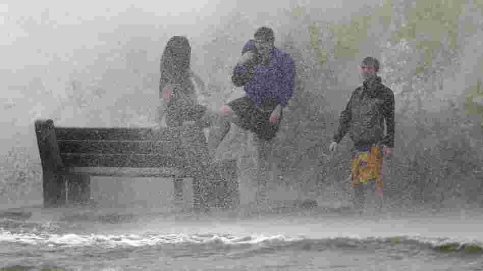 People walk in the storm surge from Hurricane Isaac along Lake Pontchartrain in New Orleans. Isaac was later downgraded to a tropical storm as it continued to grind its way through the Gulf Coast, dropping torrential rain and generating dangerous storm surges.