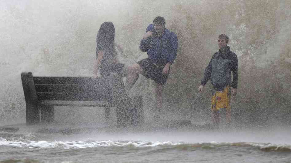 People walk in the storm surge from Hurricane Isaac along Lake Pontchartrain in New Orleans. Isaac was later downgraded to a tropical storm as it continued to grind its way through the Gulf Coast, dropping torrential rain and generating dangerous storm surges.
