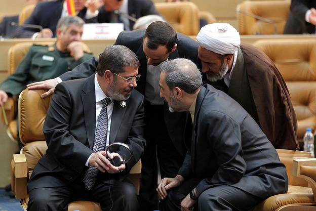 Egyptian President Mohamed Morsi, left, speaks with former Iranian foreign minister Ali Akbar Velayati, right, during the opening of the Nonaligned Movement summit in Tehran.