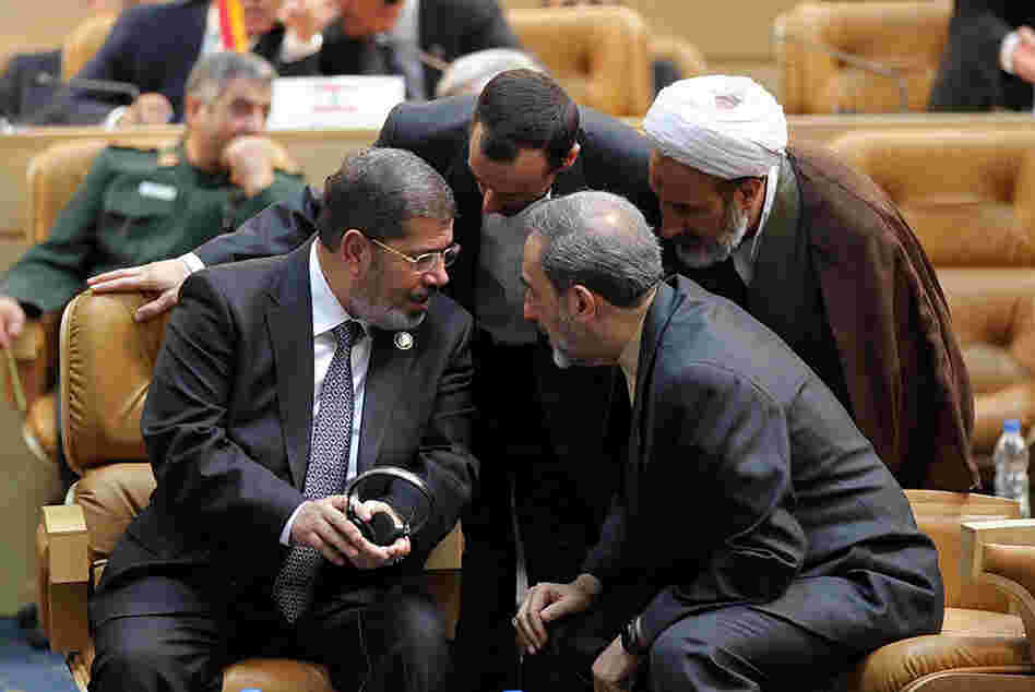 Egyptian President Mohamed Morsi, left, speaks with former Iranian foreign minister Ali Akbar Velayati, right, during the opening of the Nonaligned Movement summit in Tehran.