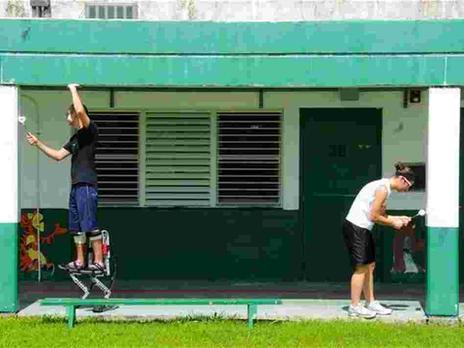 Staff Sgt. Jesse Parker (left) and Airman 1st Class Alisha Burns, 644th Combat Communications Squadron, work together to paint the Daniel L. Perez Elementary School.