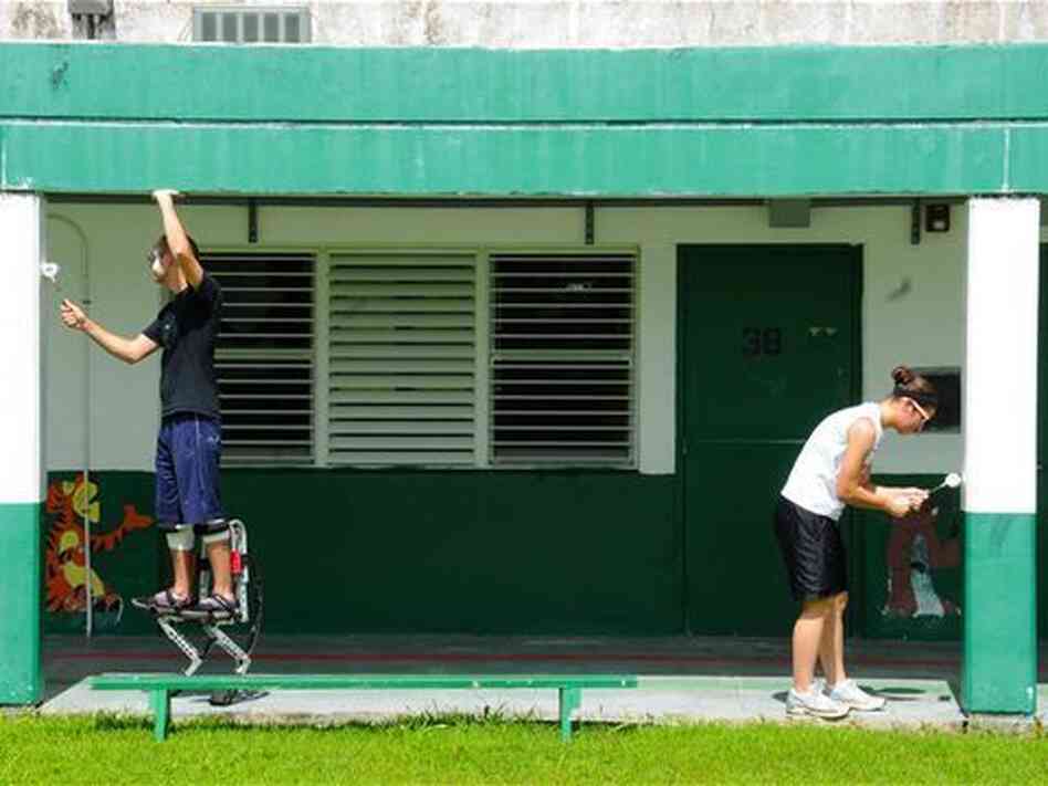 Staff Sgt. Jesse Parker (left) and Airman 1st Class Alisha Burns, 644th Combat Communications Squadron, work together to paint the Daniel L. Perez Elementary School.