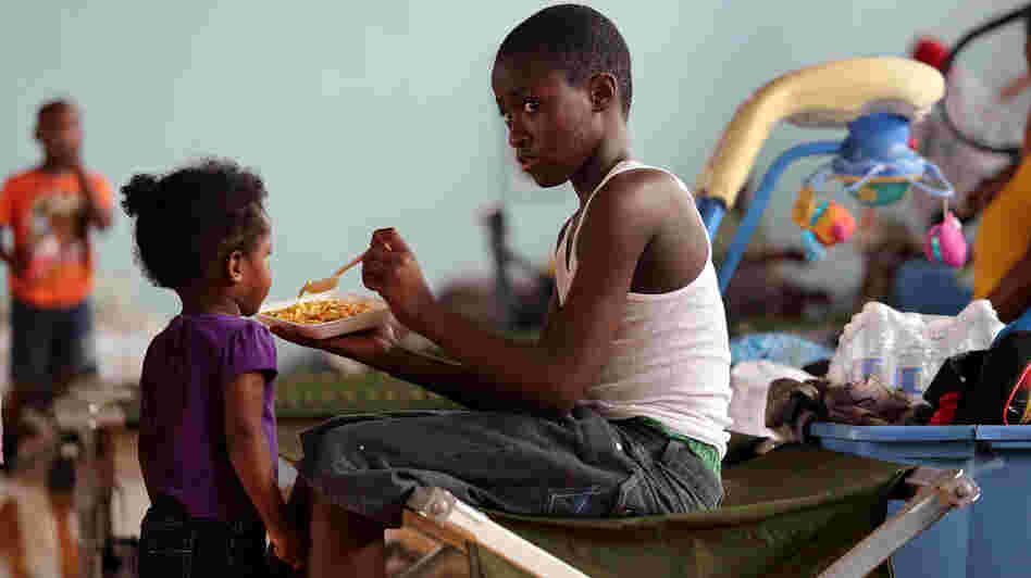 Darrell Hill, 11, feeds his sister Floy Dillon, 2, at a flood shelter in a school gym in Kentwood, La., Thursday. Residents fled to the shelter after officials announced that a dam upstream in Mississippi was in danger of bursting.