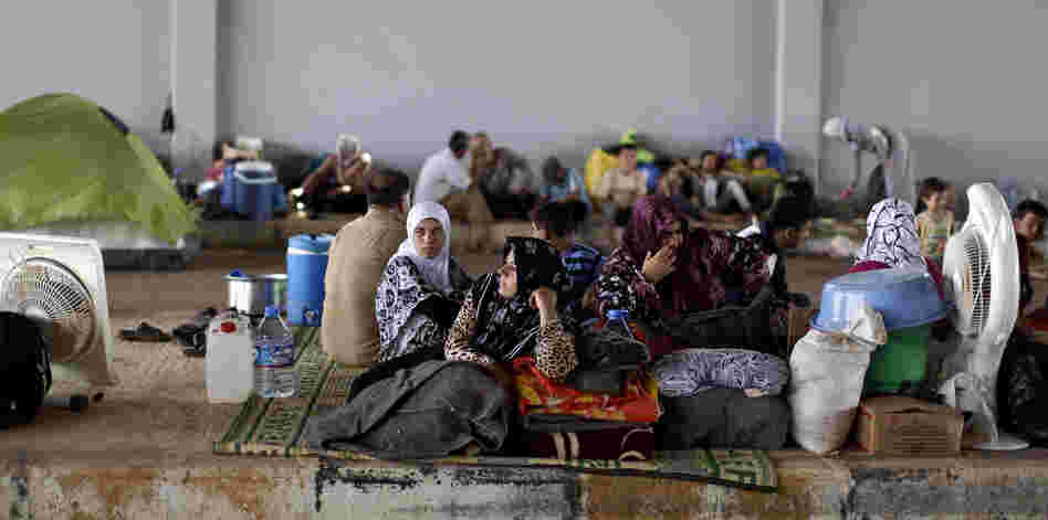 Syrians take refuge Thursday at the Bab Al-Salameh border crossing near the Syrian town of Azaz, in hopes of entering one of the refugee camps in Turkey.