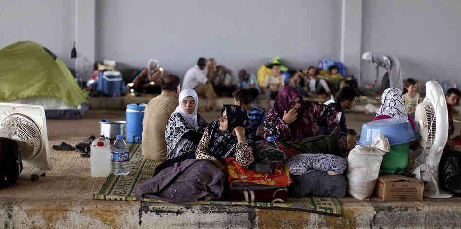 Syrians take refuge Thursday at the Bab Al-Salameh border crossing near the Syrian town of Azaz, in hopes of entering one of the refugee camps in Turkey.