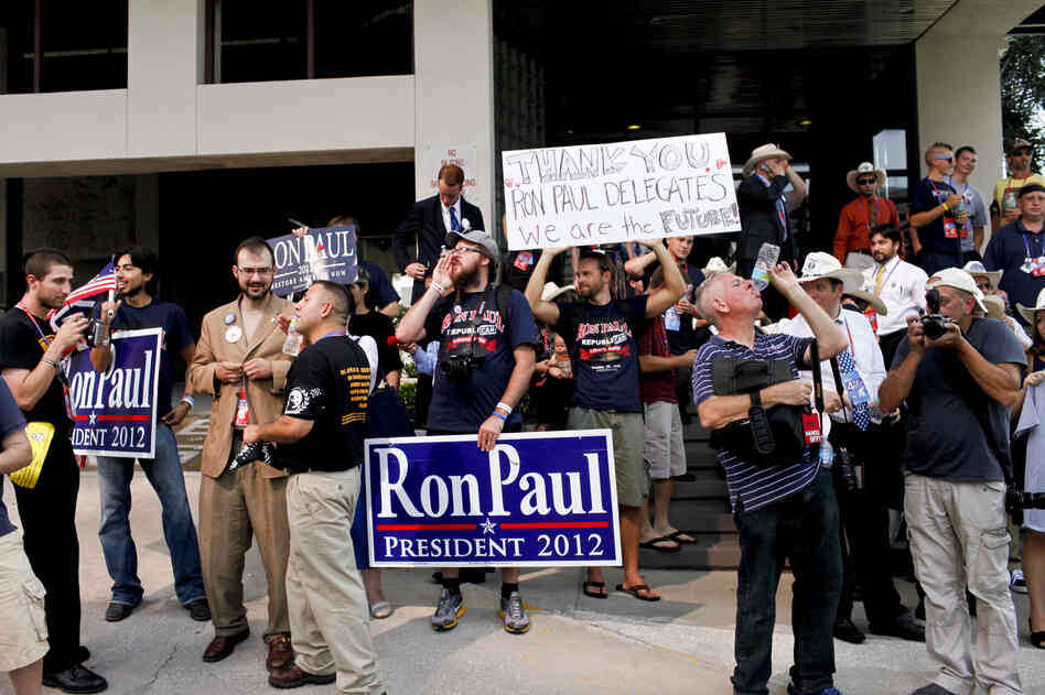 Protesters who support Ron Paul gather near the entrance to the Tampa Bay Forum.