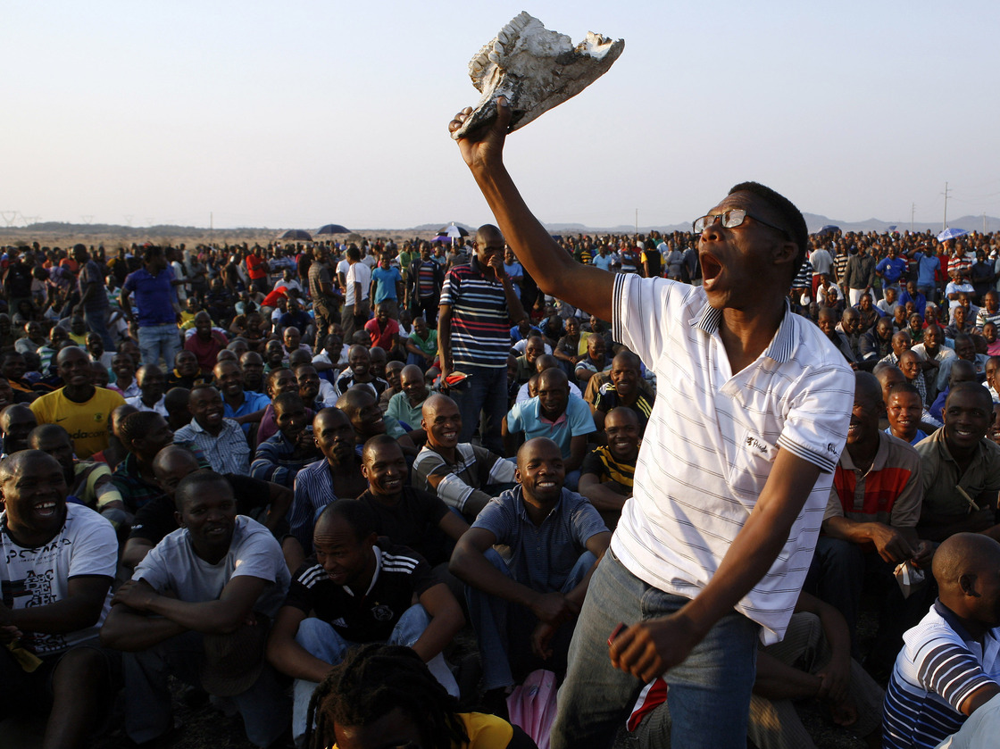 A mine worker sings and dances during a gathering at the Lonmin Platinum Mine near Rustenburg, South Africa, on Wednesday. Some 270 miners were charged with murder Thursday in connection with the  deaths of 34 of their striking colleagues.