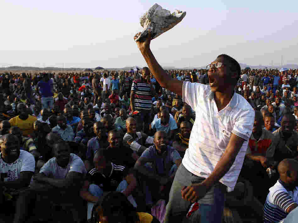 A mine worker sings and dances during a gathering at the Lonmin Platinum Mine near Rustenburg, South Africa, on Wednesday. Some 270 miners were charged with murder Thursday in connection with the  deaths of 34 of their striking colleagues.