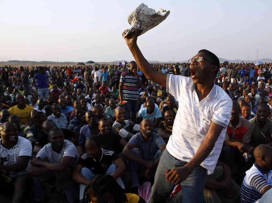 A mine worker sings and dances during a gathering at the Lonmin Platinum Mine near Rustenburg, South Africa, on Wednesday. Some 270 miners were charged with murder Thursday in connection with the  deaths of 34 of their striking colleagues.