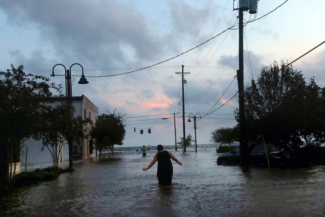 A woman walks through flood waters from Hurricane Isaac's storm surge on the north shore of Lake Pontchartrain Thursday.
