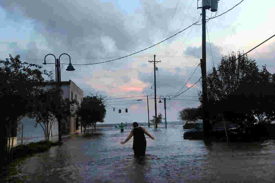 A woman walks through flood waters from Hurricane Isaac's storm surge on the north shore of Lake Pontchartrain Thursday.