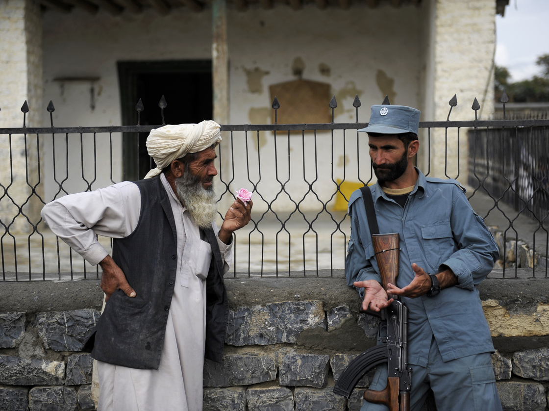 Afghan security forces are already playing a more prominent role, though questions remain about the quality of the forces. Here, an Afghan policeman talks with an elderly man in the eastern province of Khost in August.