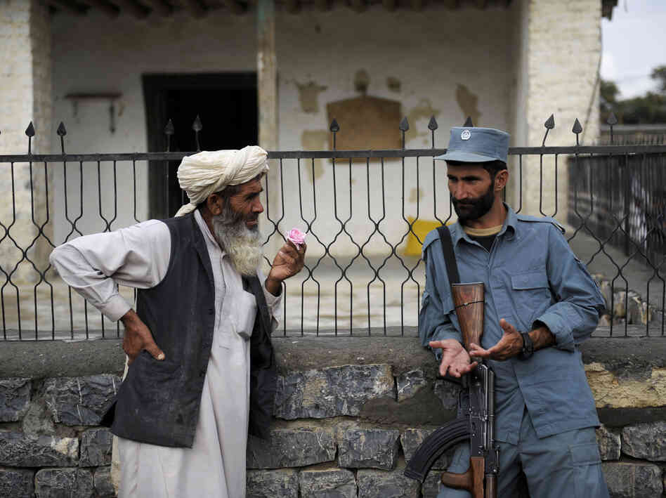 Afghan security forces are already playing a more prominent role, though questions remain about the quality of the forces. Here, an Afghan policeman talks with an elderly man in the eastern province of Khost in August.
