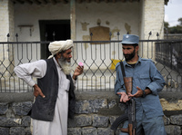 Afghan security forces are already playing a more prominent role, though questions remain about the quality of the forces. Here, an Afghan policeman talks with an elderly man in the eastern province of Khost in August.