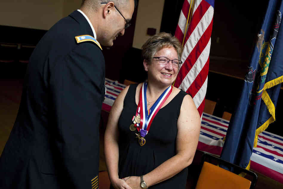 Retired Army Maj. Michelle Dyarman, shown with Lt. Col. William McDonough, smiles after receiving a Purple Heart and other medals for her military service. Retired Army Maj. Michelle Dyarman, shown with Lt. Col. William McDonough, smiles after receiving a Purple Heart and other medals for her military service.