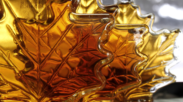 Maple syrup bottles sit on a shelf. A Canadian syrup producers' federation says a warehouse holding "over 10 million pounds of maple syrup" was recently burglarized.