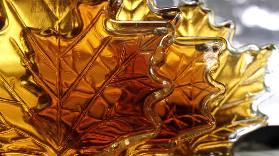Maple syrup bottles sit on a shelf. A Canadian syrup producers' federation says a warehouse holding "over 10 million pounds of maple syrup" was recently burglarized.