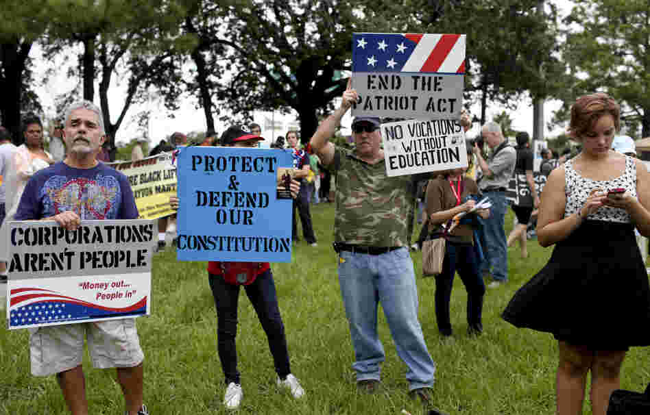 From left, Mike Garcia, Terri Schultz-Rivers, Tim Rivers and Alissah Depiro, all of Tampa, attend a rally and march organized by the Occupy movement in downtown Tampa on Monday. Turnout was much lower than expected, and rain drenched the crowd.