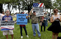 From left, Mike Garcia, Terri Schultz-Rivers, Tim Rivers and Alissah Depiro, all of Tampa, attend a rally and march organized by the Occupy movement in downtown Tampa on Monday. Turnout was much lower than expected, and rain drenched the crowd.