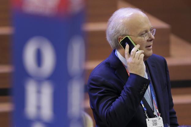 Karl Rove talks on his mobile phone as he walks across the floor before the second session of the Republican National Convention in Tampa on Tuesday.