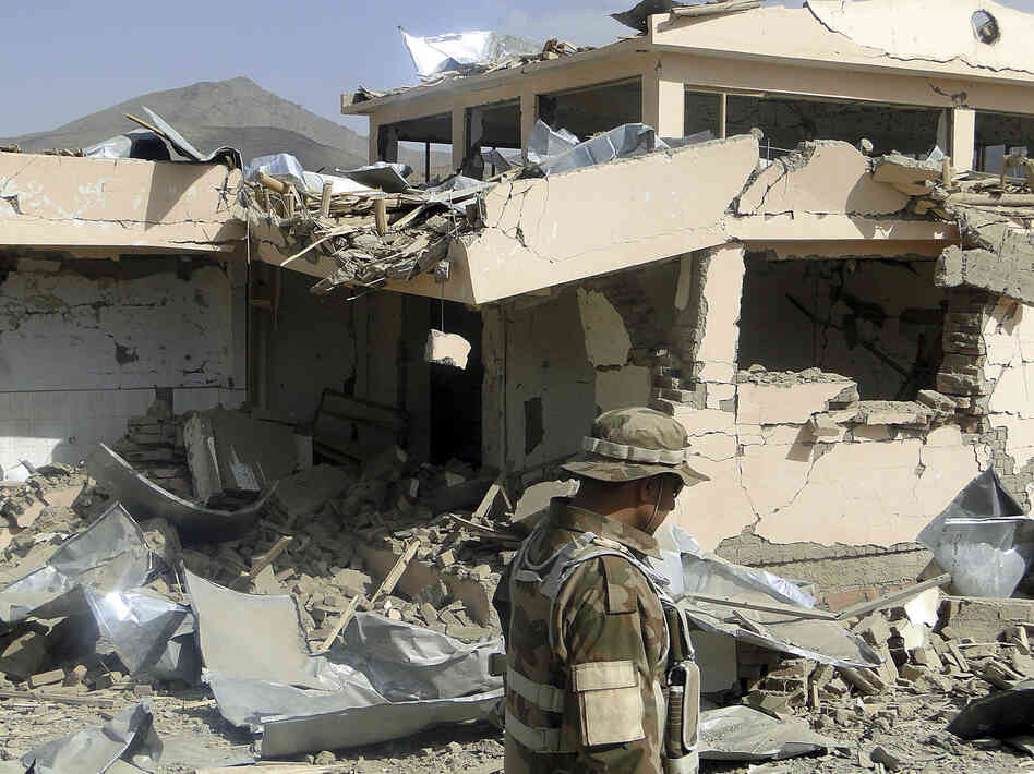 A security official looks at rubble of a building destroyed during a twin suicide bomb attack in Wardak province, Afghanistan, on Saturday.