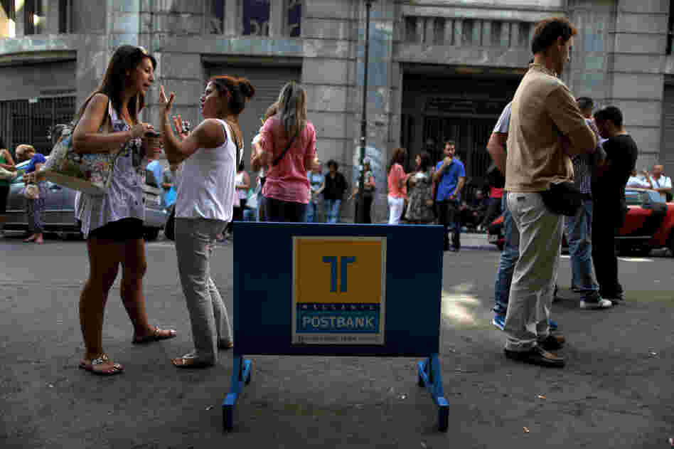 Striking Hellenic Postbank workers chat outside the state-owned bank's headquarters in Athens on Thursday. The union is protesting the government's plan to sell its majority share in the lender.